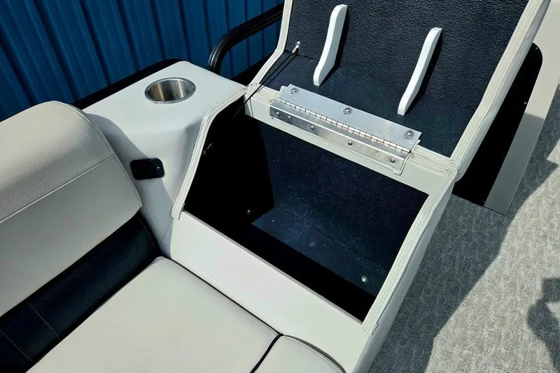 Slide: The Image of 2020 Tahoe 225 boat interior with open storage compartment and cup holder. - 21