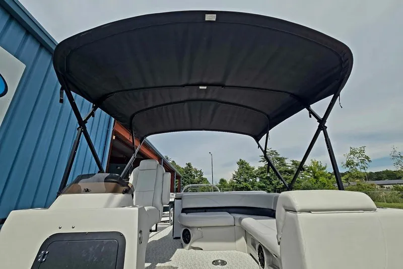 Slide: The Image of 2020 Tahoe 225 boat interior with canopy, featuring white seating and helm. - 39