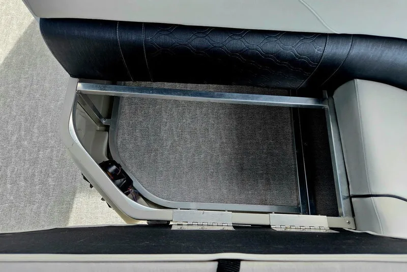 Slide: The Image of Open storage compartment in 2020 Tahoe 225 boat seat, featuring metal frame and upholstery. - 31