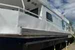 The Image of 1982 Masterfab 65 houseboat with white exterior, docked under a partly cloudy sky. - 0