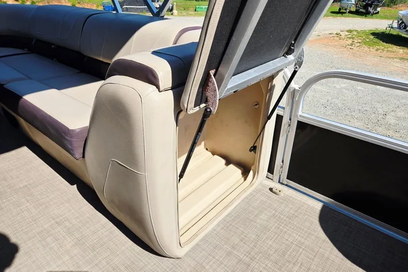 Slide: The Image of 2018 Sun Tracker Party Barge 22 XP3 storage compartment with open seat revealing interior space. - 27