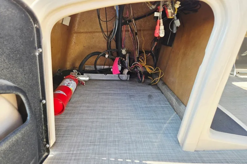 Slide: The Image of Interior view of a 2018 Sun Tracker Party Barge 22 XP3, showing wiring and a fire extinguisher. - 33
