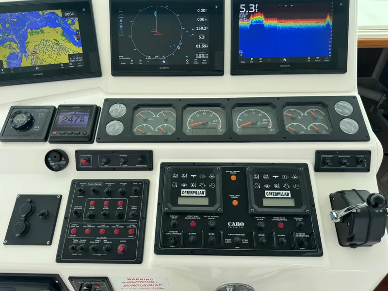 Slide: The Image of Control panel of a 1999 Cabo 45 Express boat with navigation and engine displays. - 22