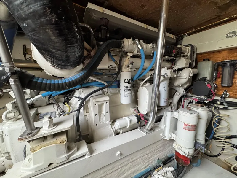 Slide: The Image of Engine room of 1999 Cabo 45 Express boat with CAT components and blue hoses. - 43