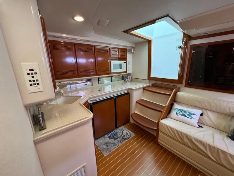 Slide: The Image of Interior of 1999 Cabo 45 Express yacht with kitchen and seating area. - 39