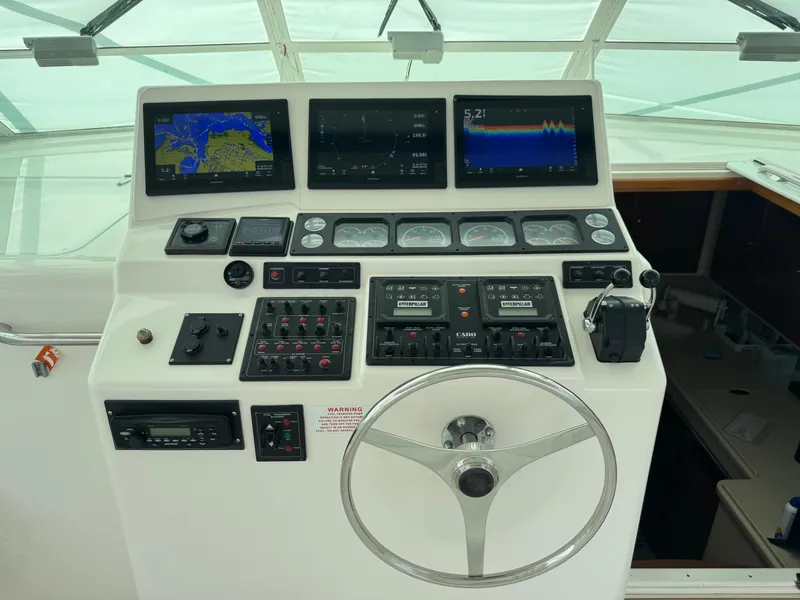 Slide: The Image of 1999 Cabo 45 Express helm with navigation screens and controls. - 21