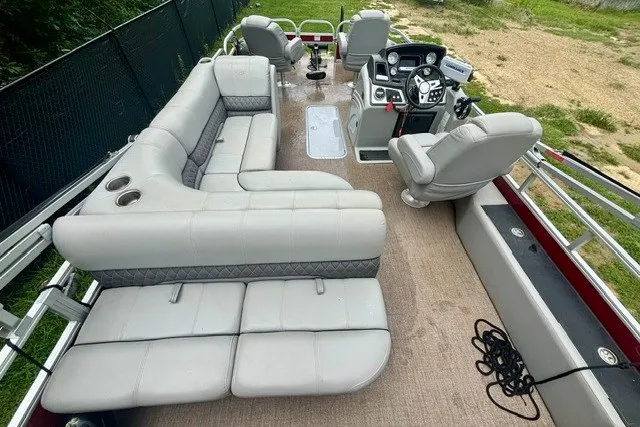 Slide: The Image of 2023 Ranger 223F pontoon boat with spacious seating and modern helm, docked on grassy shore. - 6