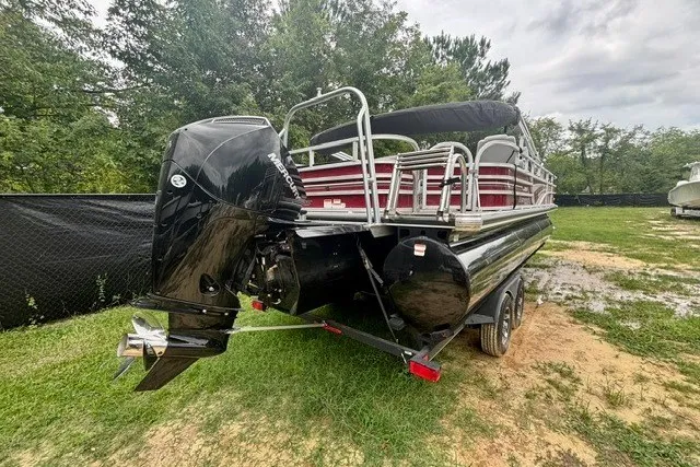 Slide: The Image of 2023 Ranger 223F pontoon boat with outboard motor, parked on grass. - 5