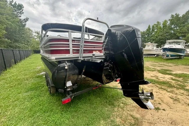 Slide: The Image of 2023 Ranger 223F boat with powerful outboard motor, parked on grassy area. - 4