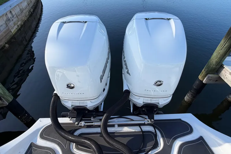 Slide: The Image of Twin Mercury outboard engines on a 2022 Glasstream 328 Pro-XS boat, docked by calm water. - 48