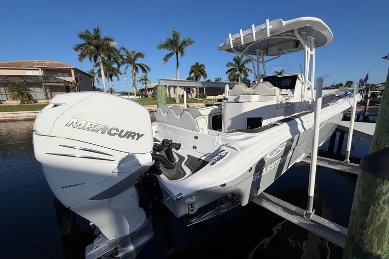 Slide: The Image of 2022 Glasstream 328 Pro-XS boat with Mercury Verado engine, docked near palm trees. - 1
