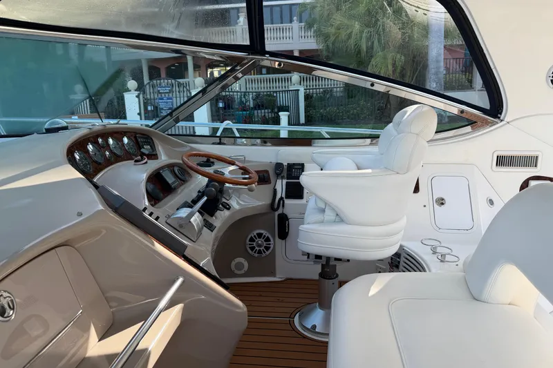 Slide: The Image of Interior cockpit of 2001 Sea Ray Sundancer 510 yacht with white seating and wooden accents. - 13
