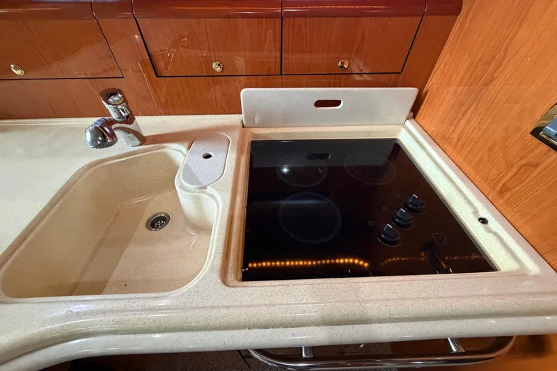Slide: The Image of Kitchen area of 2001 Sea Ray Sundancer 510 with sink and stovetop. - 26