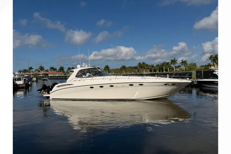 Slide: The Image of 2001 Sea Ray Sundancer 510 yacht docked on calm water under a clear blue sky. - 55