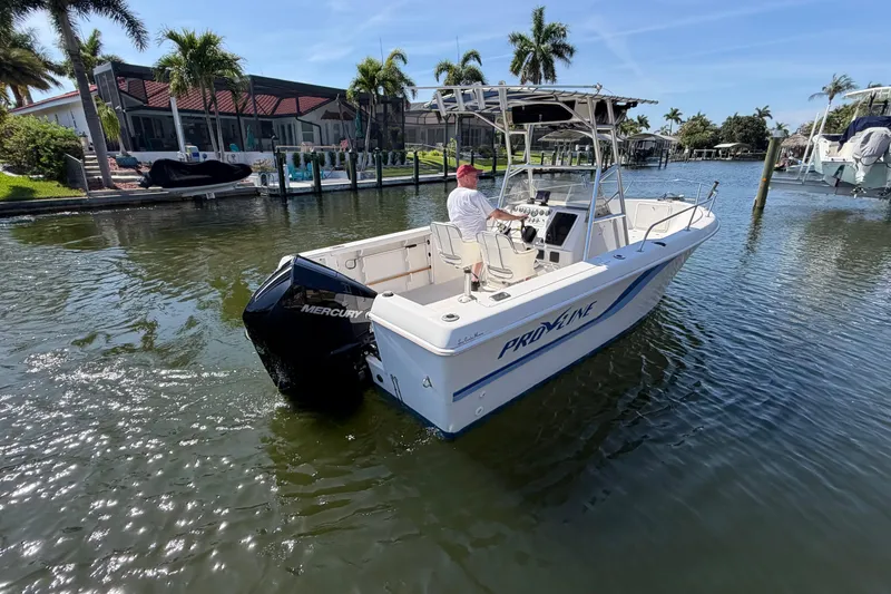 The Image of 1995 Pro-Line 21 Sport boat with Mercury engine on a sunny waterfront. - 1