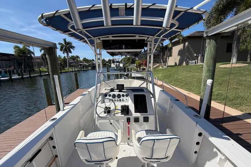 Slide: The Image of 1995 Pro-Line 21 Sport boat with center console, docked by a canal under clear skies. - 8