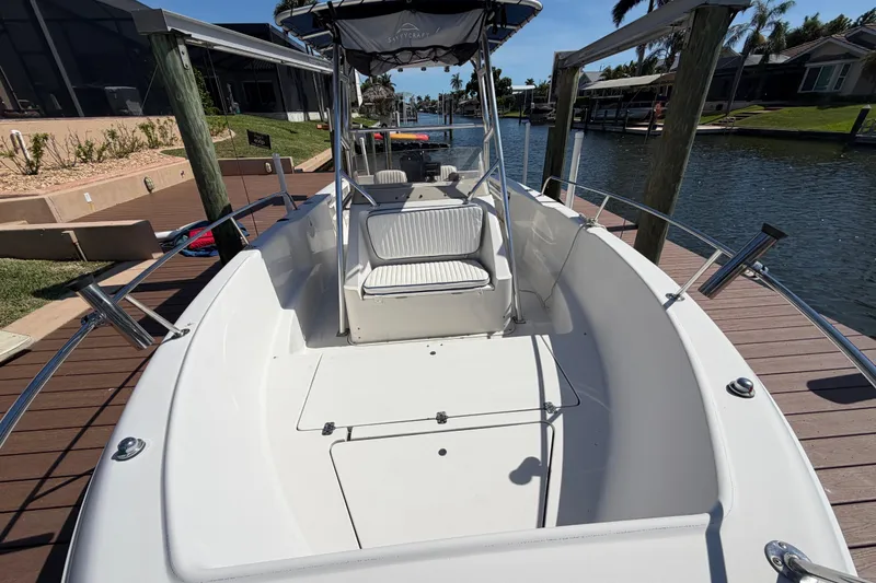 Slide: The Image of 1995 Pro-Line 21 Sport boat docked on a sunny day, showcasing spacious deck and seating. - 16