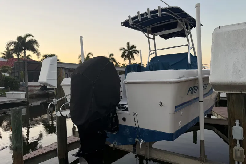 Slide: The Image of 1995 Pro-Line 21 Sport boat docked at sunset with covered outboard motor. - 22