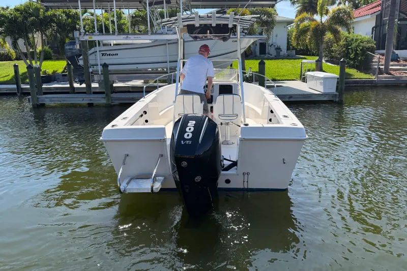 Slide: The Image of 1995 Pro-Line 21 Sport boat with V6 engine, docked in a sunny marina. - 2