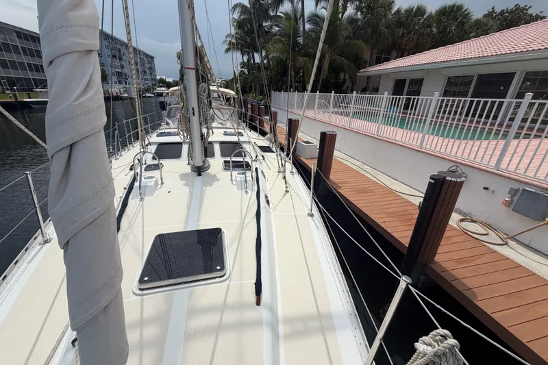 Slide: The Image of 2009 Hylas 54 sailboat docked near waterfront homes and palm trees. - 36