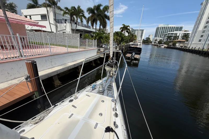Slide: The Image of Bow of a 2009 Hylas 54 yacht docked in a scenic canal with palm trees. - 33