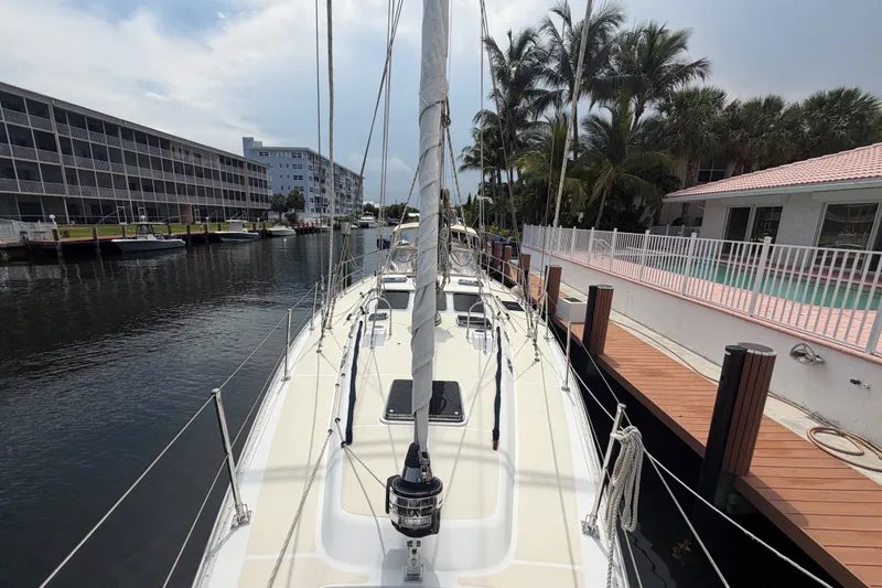 Slide: The Image of Sailboat docked in a canal, Hylas 54 model, 2009, surrounded by buildings and palm trees. - 34