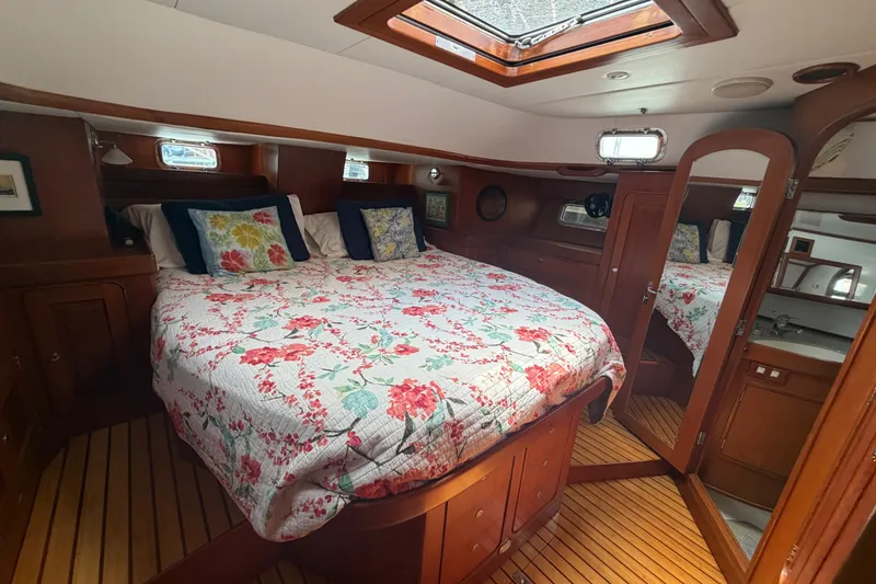 Slide: The Image of Luxurious 2009 Hylas 54 yacht cabin with floral bedding and wooden interior. - 20
