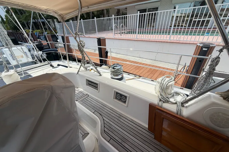 Slide: The Image of 2009 Hylas 54 yacht deck with ropes and seating, docked near a poolside. - 27