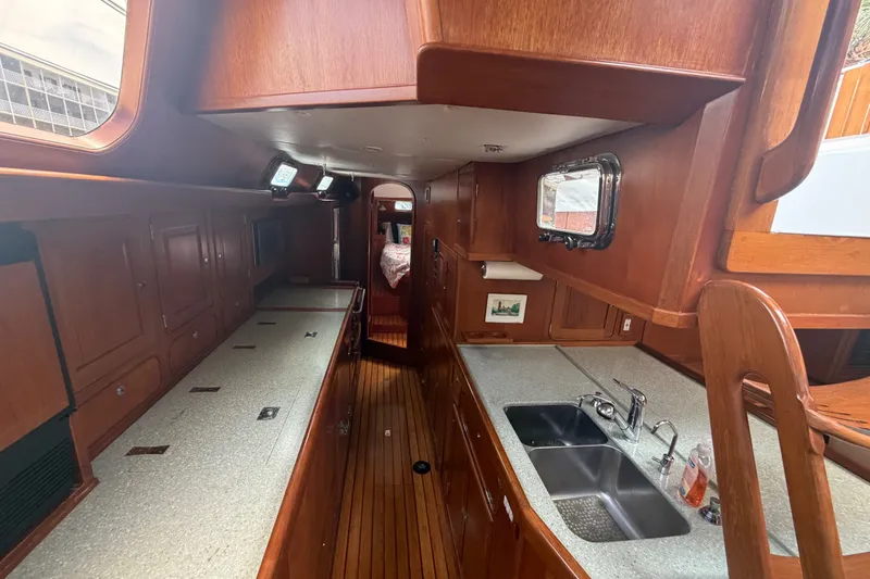 Slide: The Image of Interior of 2009 Hylas 54 yacht featuring a spacious galley with wooden cabinetry. - 9