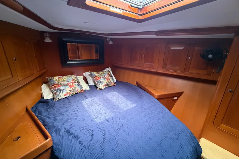 Slide: The Image of Cozy cabin interior of 2009 Hylas 54 yacht with blue bedding and floral pillows. - 14