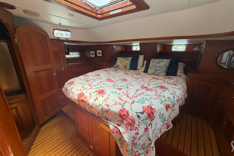 Slide: The Image of Luxurious 2009 Hylas 54 yacht cabin with floral bedding and rich wood interior. - 24