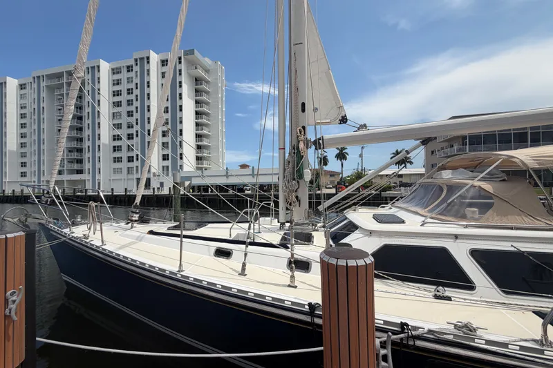 Slide: The Image of 2009 Hylas 54 sailboat docked near modern waterfront buildings. - 38