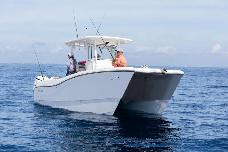 Slide: The Image of 2026 World Cat 295CC boat on open water, two people fishing. - 14