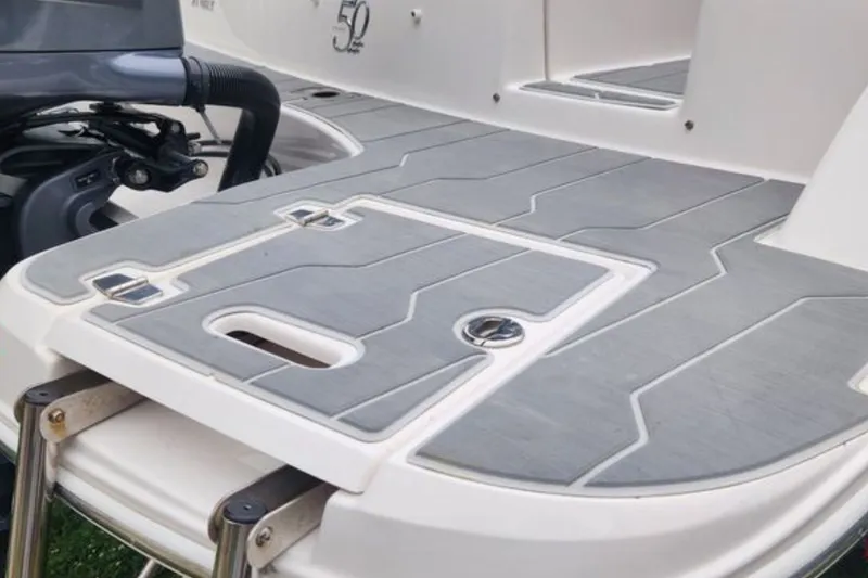 Slide: The Image of 2020 Regal 21 OBX boat swim platform with gray decking and motor detail. - 7