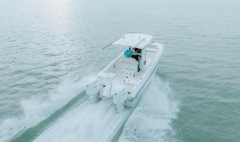 Slide: The Image of 2026 World Cat 235TE boat cruising on open water, rear view. - 6