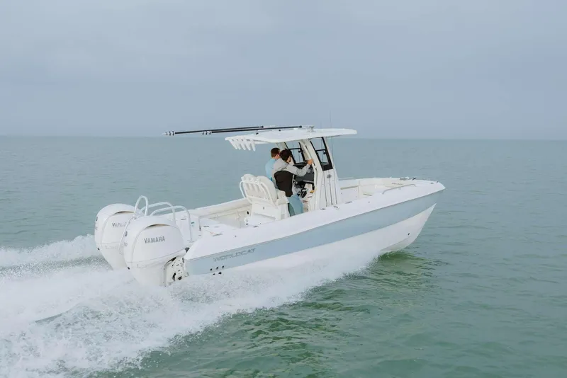 Slide: The Image of 2026 World Cat 235TE boat cruising on open water with dual Yamaha engines. - 2
