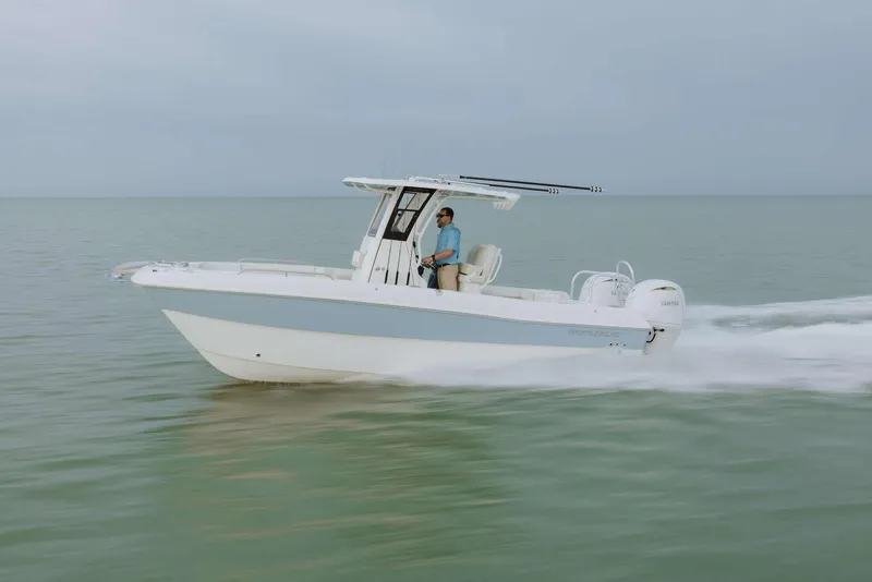 Slide: The Image of 2026 World Cat 235TE boat cruising on calm water with a person at the helm. - 10
