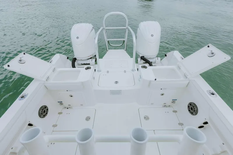 Slide: The Image of 2026 World Cat 235TE boat deck with dual engines and open storage compartments. - 44