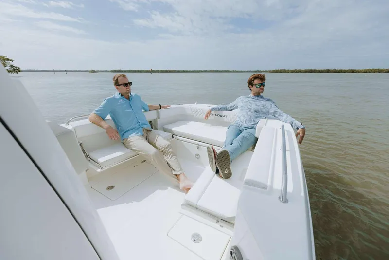 Slide: The Image of Two people relaxing on a 2026 World Cat 235TE boat in calm waters. - 26