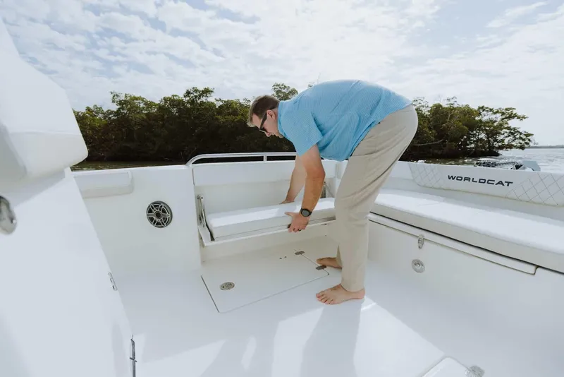Slide: The Image of Man adjusting seat on 2026 World Cat 235TE boat deck. - 24