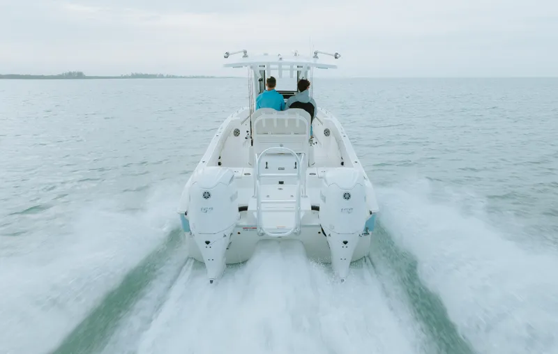 Slide: The Image of 2026 World Cat 235TE boat cruising on open water, rear view. - 7