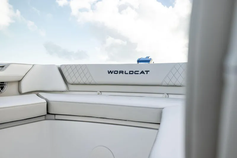 Slide: The Image of 2026 World Cat 325CC boat interior with white cushioned seating and logo. - 11