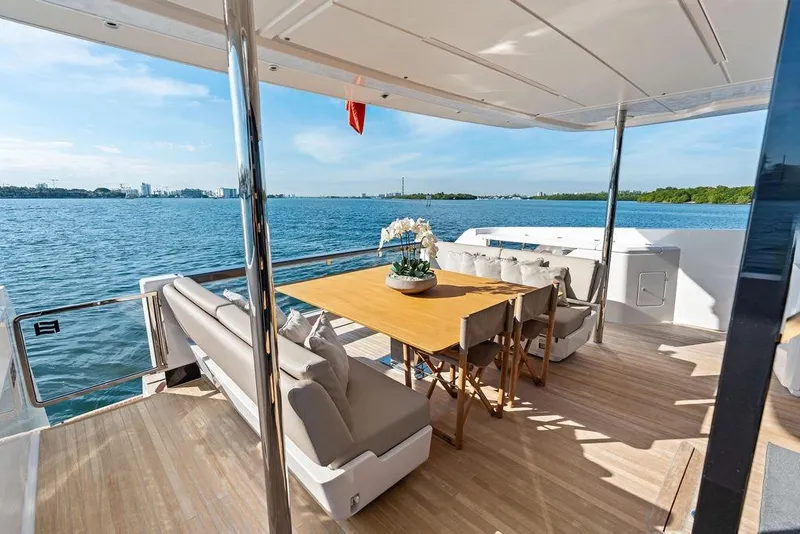 Slide: The Image of Luxurious 2023 Ferretti Yachts 860 deck with elegant dining area overlooking serene waters. - 33