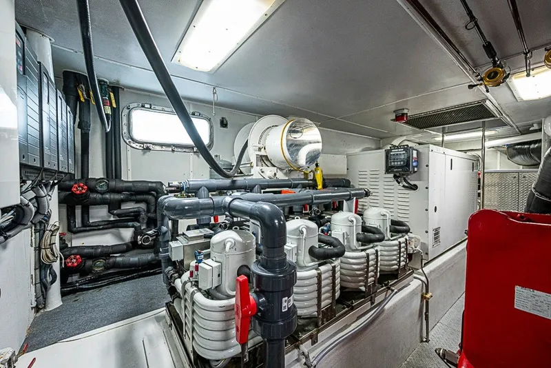 Slide: The Image of Engine room of a 1997 Delta Marine Tri-deck Motoryacht, showcasing complex machinery and piping. - 85