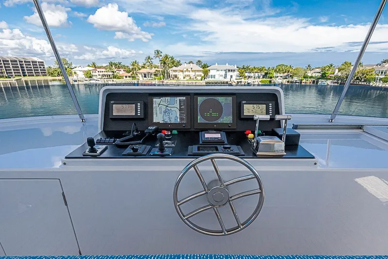 Slide: The Image of Helm of 1997 Delta Marine Tri-deck Motoryacht with navigation equipment and waterfront view. - 76
