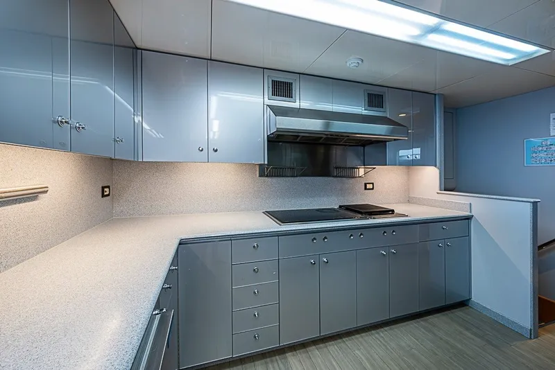 Slide: The Image of Modern kitchen in a 1997 Delta Marine Tri-deck Motoryacht with sleek cabinetry and stovetop. - 16
