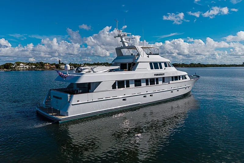 Slide: The Image of Luxurious 1997 Delta Marine Tri-deck Motoryacht cruising on a serene waterway under a clear sky. - 89
