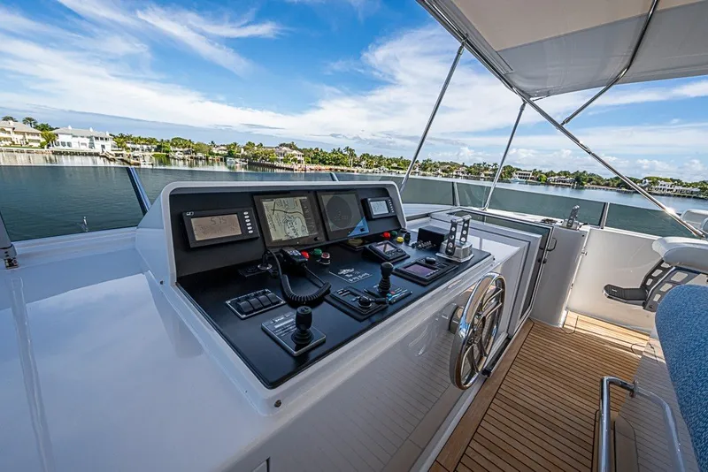 Slide: The Image of Helm of 1997 Delta Marine Tri-deck Motoryacht with navigation controls and scenic waterfront view. - 80