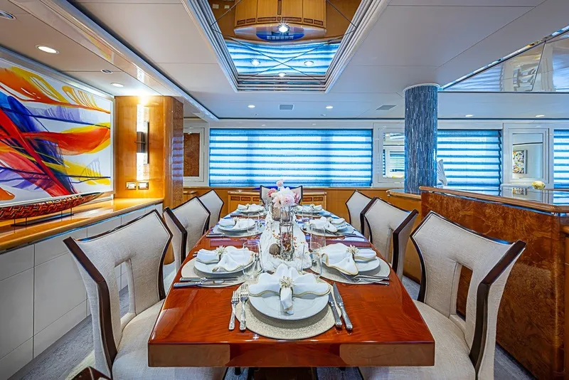 Slide: The Image of Luxurious dining area on 1997 Delta Marine Tri-deck Motoryacht with elegant table setting and vibrant artwork. - 12