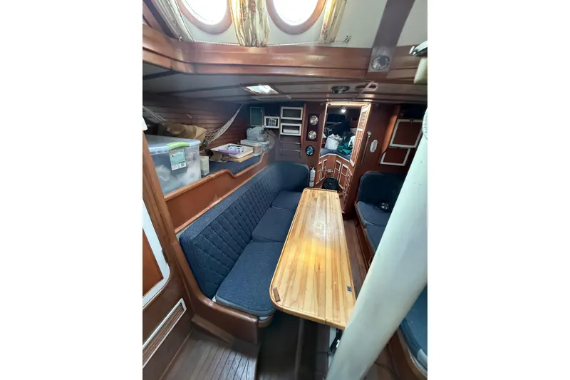Slide: The Image of Cozy 1990 Custom 46 yacht interior with wooden table and blue seating. - 19